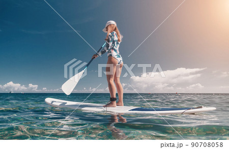 Healthy happy fit woman in bikini relaxing on a sup surfboard, floating on the clear turquoise sea water. Recreational Sports. Stand Up Paddle boarding. Summer fun, holidays travel. Active lifestyle Healthy happy fit woman in bikini relaxing on a sup surfboard, floating on the clear turquoise sea water. Recreational Sports. Stand Up Paddle boarding. Summer fun, holidays travel. Active lifestyle 90708058
