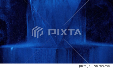 Glitter mist texture. Ink water splash. Underwater cascade. Neon navy blue paint drops floating over ice geometric figure on dark black abstract background. Glitter mist texture. Ink water splash. Underwater cascade. Neon navy blue paint drops floating over ice geometric figure on dark black abstract background. 90709290