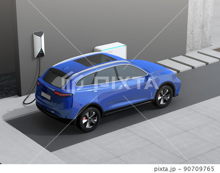 蓄電用バッテリー付きのスマートホームに充電している青色の電動SUV。 90709765