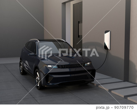 住宅ガレージに充電している黒色の電動SUV。 90709770