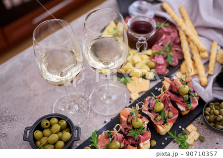 bruschetta with prosciutto ham and capers with traditional antipasto meat plate on background 90710357