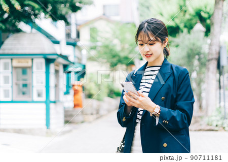 スマホを持って街を歩く女性 90711181
