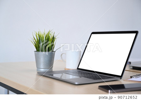 Laptop computer, smart phone, houseplant and coffee cup on wooden desk. Modern workplace 90712652