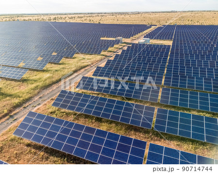 Aerial top view of a solar panels power plant. Photovoltaic solar panels at sunrise and sunset in countryside from above. Modern technology, climate care, earth saving, renewable energy concept. Aerial top view of a solar panels power plant. Photovoltaic solar panels at sunrise and sunset in countryside from above. Modern technology, climate care, earth saving, renewable energy concept. 90714744