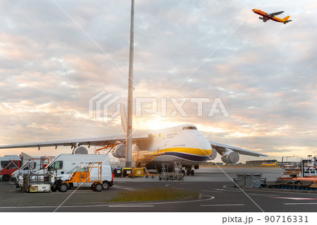 Schkeuditz, Germany - 29th May, 2022 - Large An-124-100 ukrainian Ruslan Antonov cargo jet parked on Leipzig Halle airport terminal tarmac apron for loading and service. DHL hub sunset background 90716331