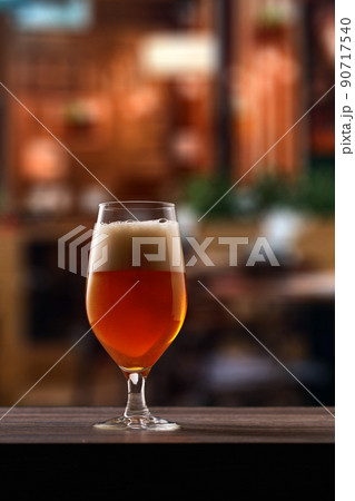 Tulip glass of beer on counter in pub. 90717540