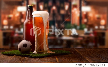 Buttle and glass of beer, soccer ball on green grass 90717541