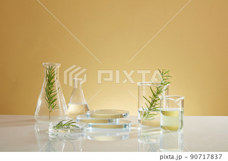 Front view of transparent podium with laboratory equipment and green leaf in beige background science content Front view of transparent podium with laboratory equipment and green leaf in beige background science content 90717837