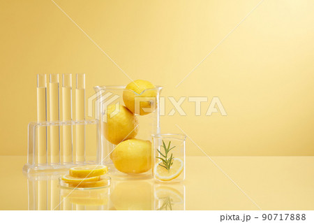 Front view of transparent podium with lemon laboratory equipment and green leaf in beige background science content Front view of transparent podium with lemon laboratory equipment and green leaf in beige background science content 90717888