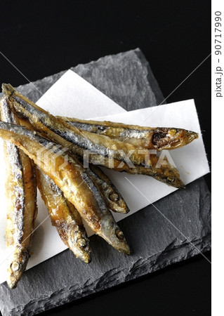スレートプレート、天紙の上のきびなごの唐揚げを黒背景で俯瞰撮影 90717990