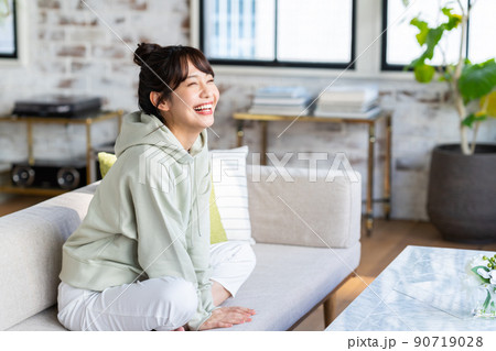 リビングでくつろぐ若い女性 リビングでくつろぐ若い女性 90719028
