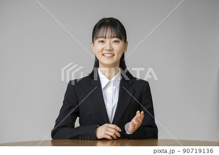 カメラ目線で話すスーツを着た若い女性　ポートレート 90719136