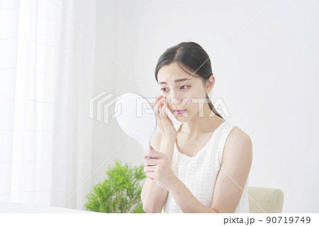 リビングでハンドミラーで顔を見て悩んでいる女性 リビングでハンドミラーで顔を見て悩んでいる女性 90719749