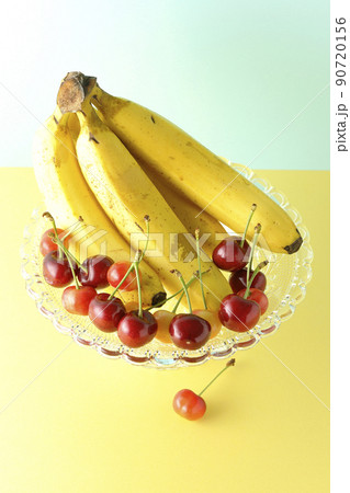 ケーキスタンドの上のバナナ1房と沢山のサクランボ。フルーツ盛り合わせ 90720156