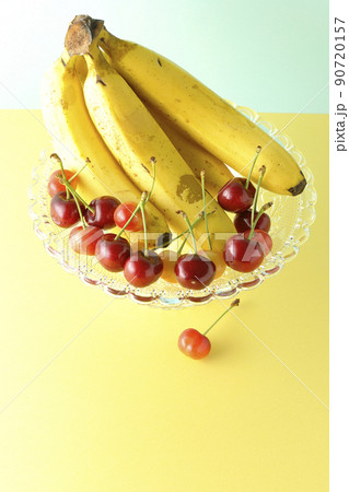 ケーキスタンドの上のバナナ1房と沢山のサクランボ。フルーツ盛り合わせ 90720157