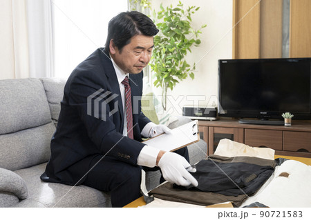 着物の査定をする買取業者の男性 90721583