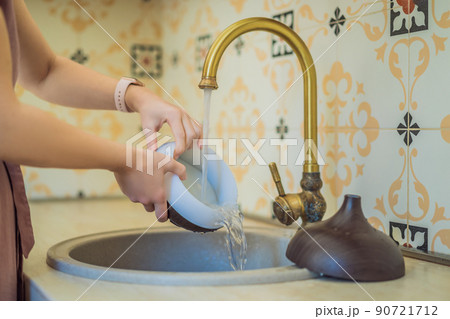 Woman washing aroma diffuser in faucet. Aromatherapy Concept. Wooden Electric Ultrasonic Essential Oil Aroma Diffuser and Humidifier. Ultrasonic aroma diffuser for home Woman washing aroma diffuser in faucet. Aromatherapy Concept. Wooden Electric Ultrasonic Essential Oil Aroma Diffuser and Humidifier. Ultrasonic aroma diffuser for home 90721712