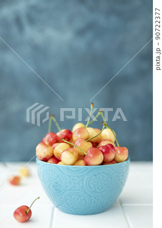 large yellow pink cherries in a blue bowl 90722377