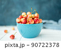 large ripe yellow pink cherries in a blue bowl 90722378