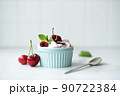 cherries with homemade greek yogurt and mint in a blue bowl 90722384