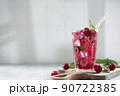 cocktail with cherry juice, mint, and ice in a glass, copy space 90722385