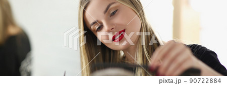 Female hairstylist with scissors and hairbrush styling haircut for male client Female hairstylist with scissors and hairbrush styling haircut for male client 90722884