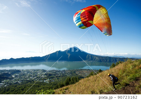 Paraglider starting from Batur volcano. Bali, Indonesia Paraglider starting from Batur volcano. Bali, Indonesia 90723162