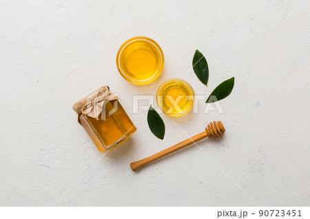 Honey jar with wooden honey dipper on white background top view with copy space. Delicious honey bottle 90723451
