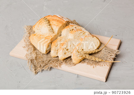 Assortment of freshly sliced baked bread with napkin on rustic table top view. Healthy unleavened bread. French bread slice 90723926