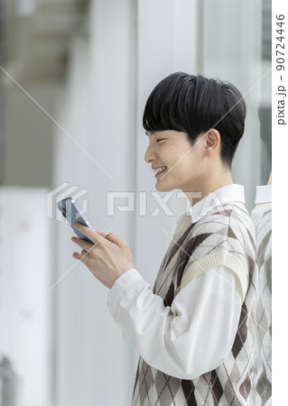 スマートフォンを持った若い男性の横顔 スマートフォンを持った若い男性の横顔 90724446