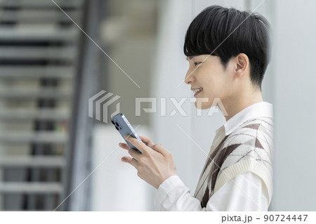 スマートフォンを持った若い男性の横顔 スマートフォンを持った若い男性の横顔 90724447