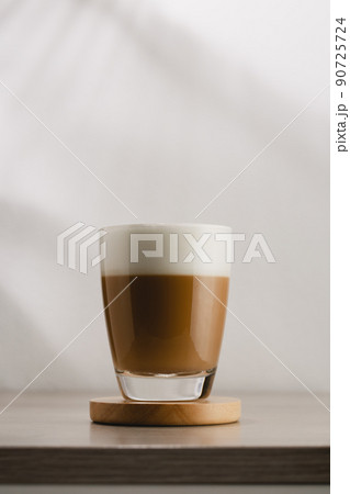 Cappuccino in a glass cup on a wooden table 90725724