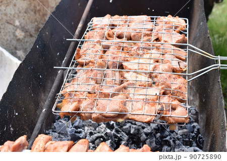 Grilled pork meat in a barbecue net with spices 90725890