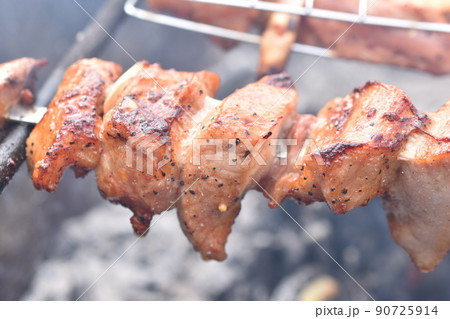 Grilled pork meat in a barbecue net with spices Grilled pork meat in a barbecue net with spices 90725914