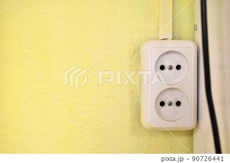 Electrical outlet on the yellow wall in the house 90726441