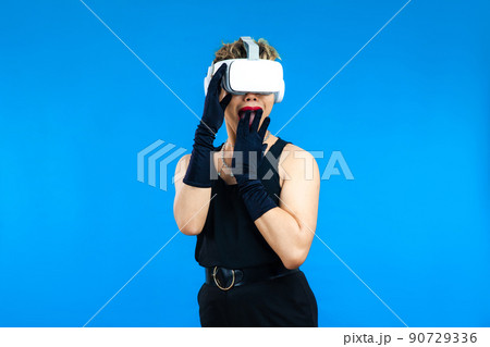 Surprised asian gay man with VR glasses posing isolated blue color background, Metaverse and Pride month Concept Surprised asian gay man with VR glasses posing isolated blue color background, Metaverse and Pride month Concept 90729336