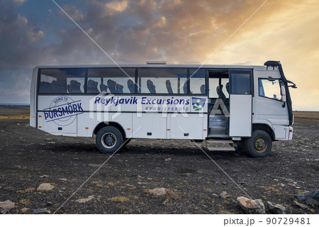 Empty Reykjavik Excursions bus parked on lava sand against sky during sunset Empty Reykjavik Excursions bus parked on lava sand against sky during sunset 90729481