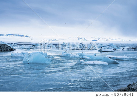 Beautiful icebergs floating in Jokulsarlon glacier lagoon against blue sky Beautiful icebergs floating in Jokulsarlon glacier lagoon against blue sky 90729641