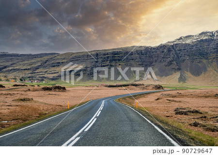 View of empty road leading towards mountain range against sky during sunset View of empty road leading towards mountain range against sky during sunset 90729647