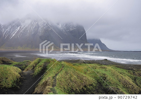 Beautiful grass on black beach against Stokksnes cape and Vestrahorn Mountain Beautiful grass on black beach against Stokksnes cape and Vestrahorn Mountain 90729742
