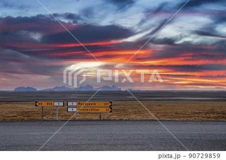 Signboards by road on volcanic landscape against dramatic sky during sunset Signboards by road on volcanic landscape against dramatic sky during sunset 90729859