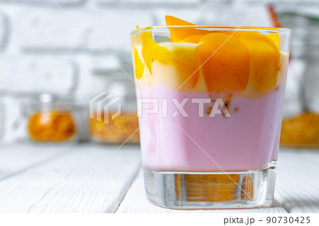 Glass cup with youghurt and fruit slices Glass cup with youghurt and fruit slices 90730425
