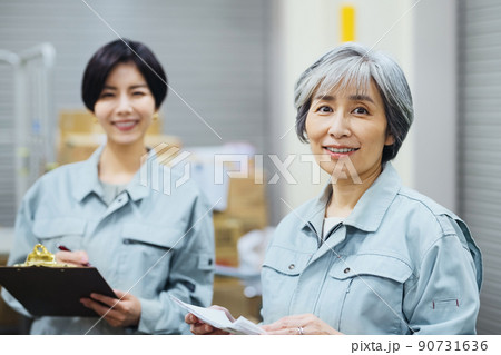 倉庫で確認する作業員の女性 倉庫で確認する作業員の女性 90731636