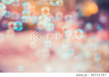 Abstract blurred of rainbow soap bubbles from the bubble blower flying on green grass. spring or summer season background. symbol of childhood. bokeh background. 90731767
