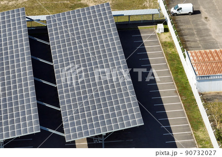 Aerial view of solar panels installed over parking lot with parked cars for effective generation of clean energy Aerial view of solar panels installed over parking lot with parked cars for effective generation of clean energy 90732027