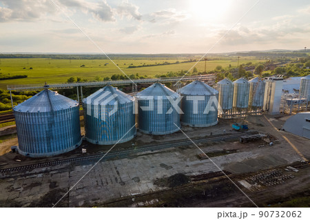 Aerial view of industrial ventilated silos for long term storage of grain and oilseed. Metal elevator for wheat drying in agricultural zone Aerial view of industrial ventilated silos for long term storage of grain and oilseed. Metal elevator for wheat drying in agricultural zone 90732062