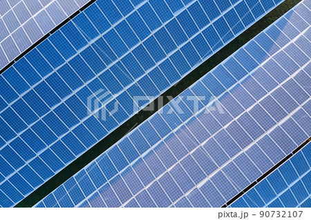 Aerial view building roof with rows of blue solar photovoltaic panels for producing clean ecological electric energy. Renewable electricity with zero emission concept Aerial view building roof with rows of blue solar photovoltaic panels for producing clean ecological electric energy. Renewable electricity with zero emission concept 90732107