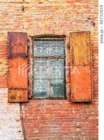 Old building brick wall with an window with hinged shutters Old building brick wall with an window with hinged shutters 90732650
