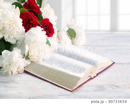Bible and a bouquet of peonies on a table 90733659