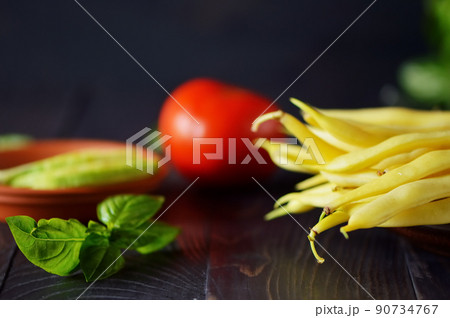 Green and yellow bean pods of asparagus on old rustic wooden table. 90734767